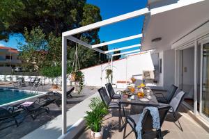 a patio with a table and chairs next to a pool at Ixian Bliss Pool Villa in Ialysos