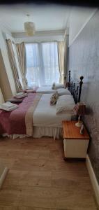 um quarto com uma cama grande e uma janela grande em Moorfield Hotel em Llandudno