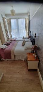 a bedroom with a large bed and a large window at St Davids & Moorfield Hotels Chapel Street in Llandudno