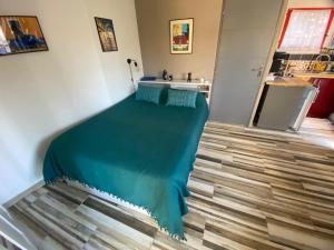 Un dormitorio con una cama con una sábana azul. en Magnifique studio dans maisonnette, en Tourrettes-sur-Loup