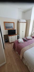um quarto com 2 camas e uma cómoda com um espelho em Moorfield Hotel em Llandudno