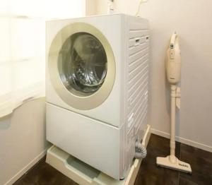 een wasmachine in een kamer met een telefoon bij ROI SPACE 鹿児島 in Kagoshima