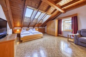 a large room with two beds and a television at Ferienwohnungen Rebmannhof in Lana