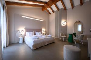 a bedroom with a bed and a table and chairs at Villa Nicolli Romantic Spa Resort - Adults Only in Riva del Garda