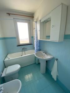 bagno blu con servizi igienici e lavandino di Orange Apartment a Marina di Massa