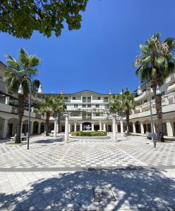 un gran edificio con palmeras delante en Orange Apartment, en Marina di Massa