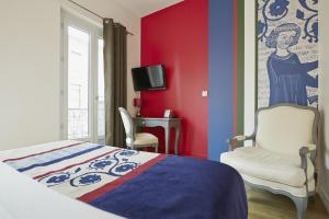 a bedroom with a bed and a chair and a painting at Hôtel St Sernin in Toulouse