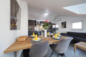een eetkamer en een keuken met een houten tafel en stoelen bij Apartments Oliva in Vrsi
