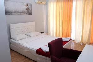 a small bedroom with a bed and a chair at Melody City Otel in Alanya