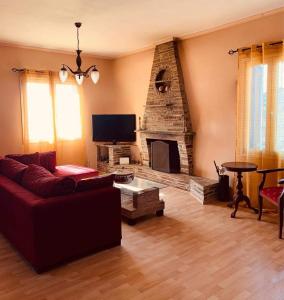a living room with a couch and a fireplace at Batsi Bay View Maisonette in Andros