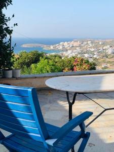 a blue chair sitting next to a table with a view at Batsi Bay View Maisonette in Andros