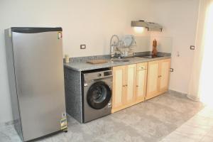a kitchen with a refrigerator and a washing machine at Villa Anna & Snake in Hurghada