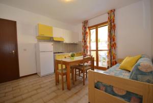 cocina y dormitorio con cama y mesa en Appartamenti Dei Fiori, en Lignano Sabbiadoro
