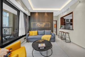 a living room with a blue couch and a table at 29Blvd BurjView in Dubai