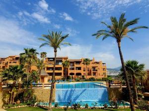 un complejo con piscina y palmeras en Secret View Benahavis en Benahavís