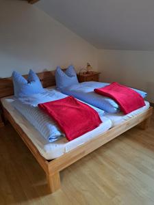 Una cama con dos toallas rojas encima. en Ferienwohnung Gipfelstürmer en Gunzesried