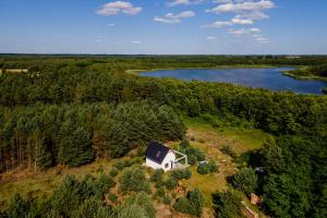 an aerial view of a house on a field next to a river at Powidzka Ostoja in Salamonowo