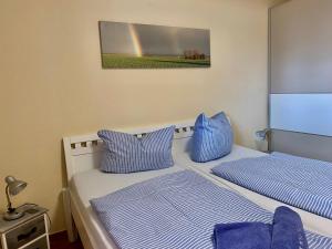 2 Betten in einem Zimmer mit Regenbogen an der Wand in der Unterkunft 2 Zimmer Appartement Poseidon in Boltenhagen