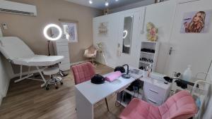 a salon with pink chairs and a white desk at Chez K&D Studio Nature avec piscine St Raphaël in Saint-Raphaël