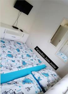 sypialnia z łóżkiem z niebiesko-białą kołdrą w obiekcie Grandeur Home Apartment Mostar w mieście Mostar