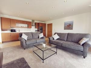 a living room with two couches and a coffee table at 1 Y Bae - Top Floor Apartment in Trearddur