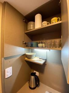 una cocina con estanterías con platos y hervidor de agua en Loft Cabrini en Villa Mercedes