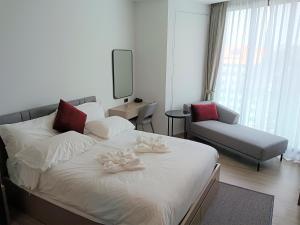 a bedroom with a bed and a couch and a chair at Edge Central Pattaya Lux in Pattaya Central