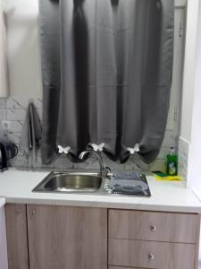 a kitchen with a sink and a shower curtain at Studio Jim in Volos