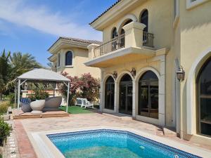 ドバイにあるVacay Lettings -Private Pool & Beach Villa at Palm Jumeirahの庭にスイミングプールがある大きな家