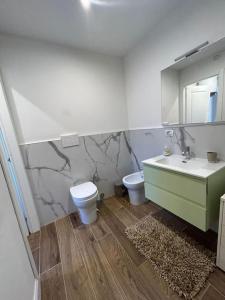 La salle de bains est pourvue d'un lavabo, de toilettes et d'un miroir. dans l'établissement Maison Regina, à Turin