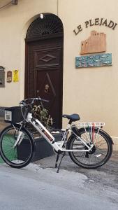 un vélo garé devant un immeuble avec une porte dans l'établissement Le Plejadi, à Castellammare del Golfo