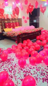 pokój z łóżkiem i mnóstwem różowych balonów w obiekcie 7K Heights w mieście Murree