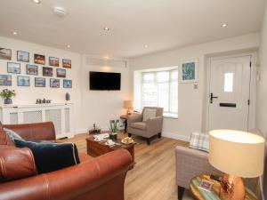 a living room with a couch and a chair at White Cottage in Bere Regis