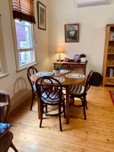 - une salle à manger avec une table et des chaises en bois dans l'établissement La Rouge Cottage, à Bendigo