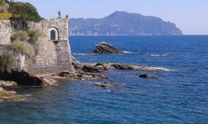 an old building on the shore of a body of water at Casa Tra Il Verde E Il Blu in Genoa