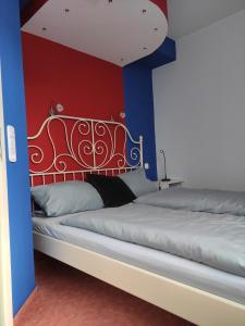 Duas camas num quarto com paredes azuis e vermelhas em FeWo Seepferdchen em Emden
