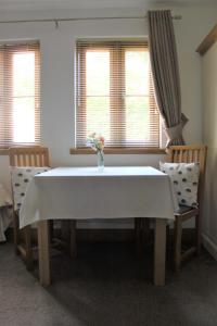 a dining room table with a white table and chairs at Langdale Lodge in Lincoln