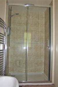 a shower with a glass door in a bathroom at Langdale Lodge in Lincoln