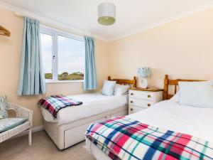 two beds in a room with a window at Westpoint in Wadebridge