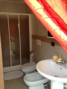 uma casa de banho com um WC branco e um lavatório. em B&B Oro Puro em Fondi