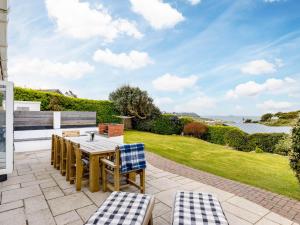 a patio with a table and chairs and a lawn at Westpoint in Wadebridge
