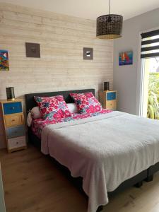 sypialnia z dużym łóżkiem z czerwonymi poduszkami w obiekcie Maison d'Hôtes La Marie Pierre w mieście Pluherlin