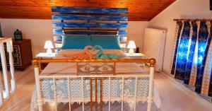 a bedroom with a bed with a blue headboard at Katia's ATTIC in Acharavi +34 photos