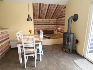 a dining room with a table and a wood stove at Holiday home Tversted, Zarrentin in Zarrentin