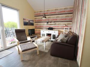 a living room with a couch and a chair at Holiday home Tversted, Zarrentin in Zarrentin