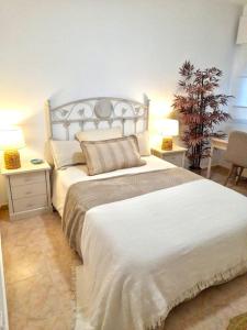 a bedroom with a large white bed with two night stands at Casa Oikos - La Cala de Mijas in La Cala de Mijas