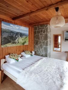 two beds in a bedroom with a large window at Dom Gościnny U LEONA in Zakopane