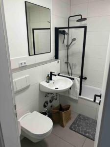 ein weißes Bad mit einem WC und einem Waschbecken in der Unterkunft Wunderschöne 1-Zimmer Wohnung in Wiesbaden
