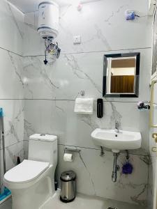 een witte badkamer met een toilet en een wastafel bij 3BHK Airport Vista Apartment - Entire Apartment in Jaipur