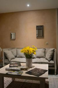 sala de estar con sofá y mesa con flores amarillas en Grand gîte écologique à la campagne et accessible, en Cabariot